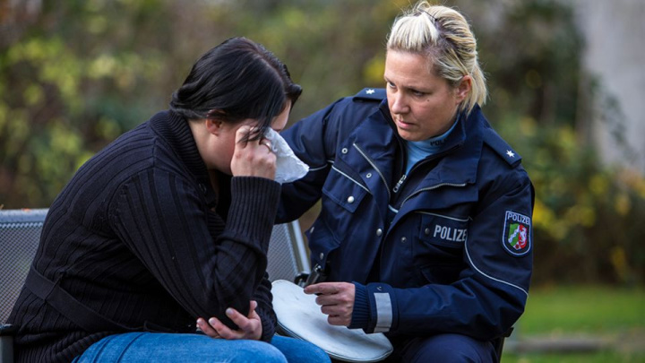 Polizistin beruhigt eine weinende Person